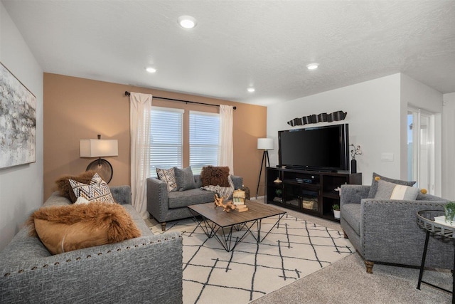 living area with recessed lighting, a textured ceiling, and light colored carpet