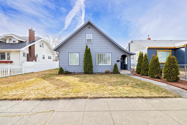 bungalow-style house featuring a front lawn and fence