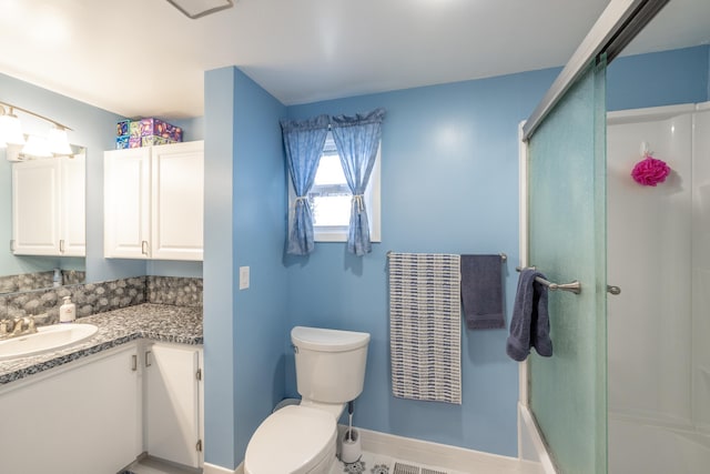 full bath featuring vanity, toilet, baseboards, and a shower with door