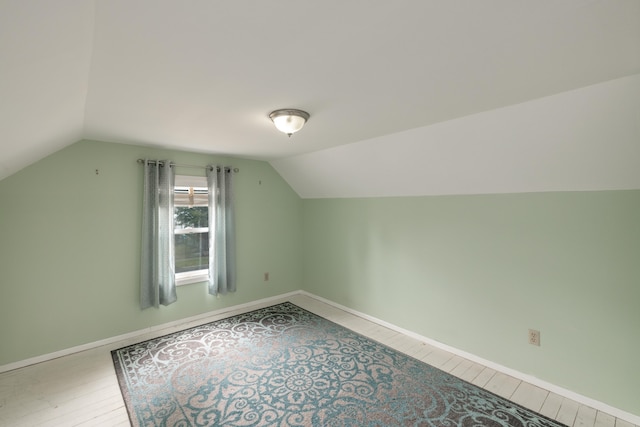 bonus room featuring baseboards, lofted ceiling, and wood finished floors