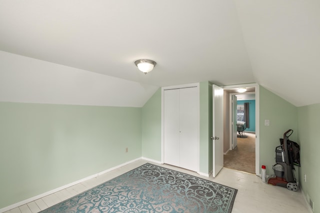 additional living space featuring lofted ceiling and baseboards