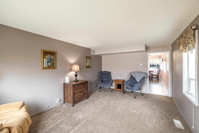 bedroom featuring carpet flooring, baseboards, visible vents, and a textured ceiling