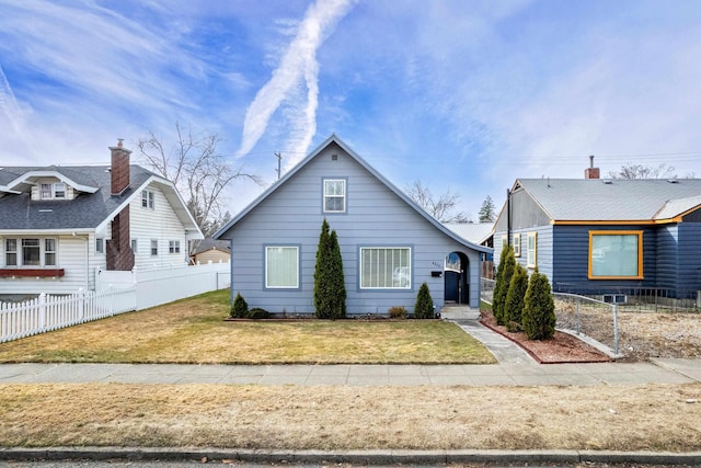 bungalow-style home featuring a front lawn and fence