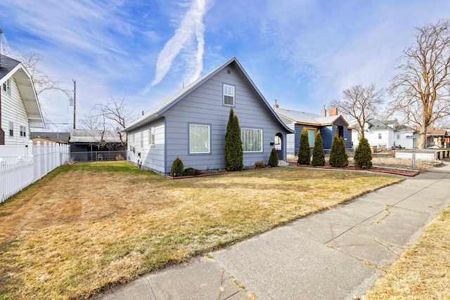 view of front of home with a front yard and fence