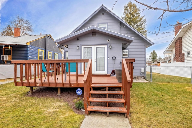 rear view of house featuring a yard, fence, and a wooden deck