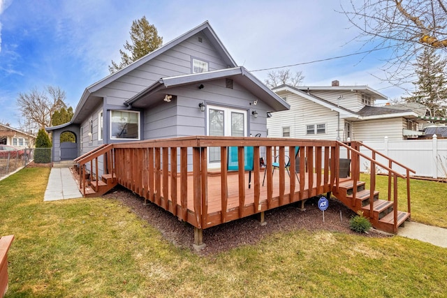 rear view of property with a deck, a yard, and a fenced backyard