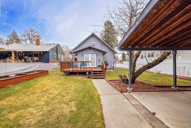 back of property featuring a lawn, french doors, a deck, and fence