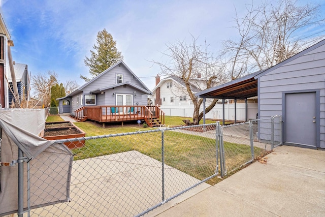 back of house featuring a gate, fence, a yard, a garden, and a wooden deck