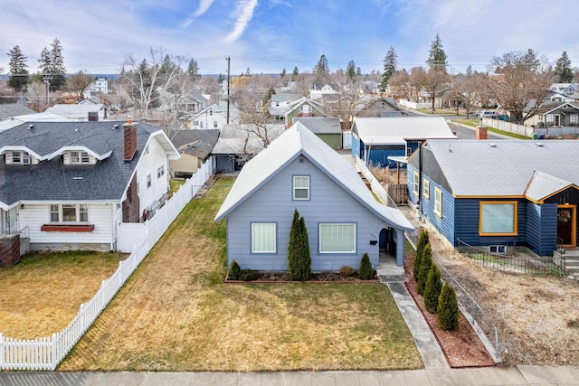 view of front of house featuring a front lawn, a fenced backyard, and a residential view