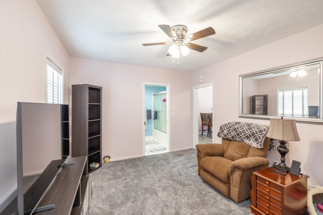 carpeted living room featuring baseboards, a textured ceiling, a healthy amount of sunlight, and ceiling fan