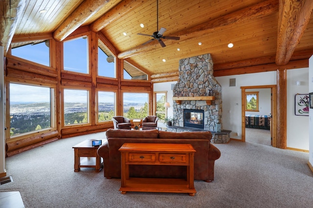 living room with beamed ceiling, carpet, and a stone fireplace