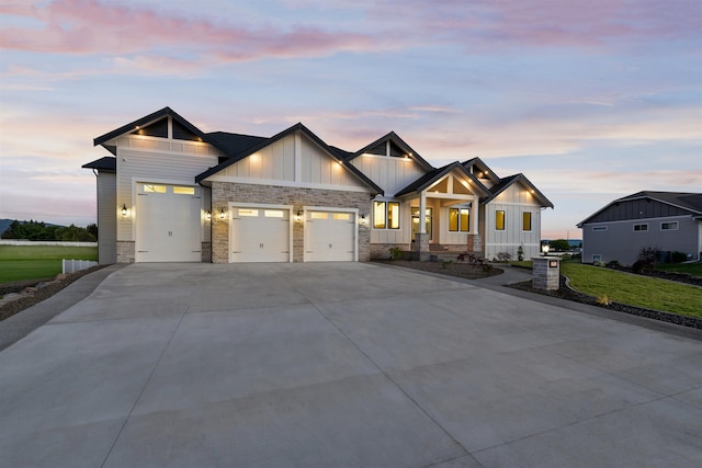 craftsman house featuring an attached garage, board and batten siding, concrete driveway, and a front lawn