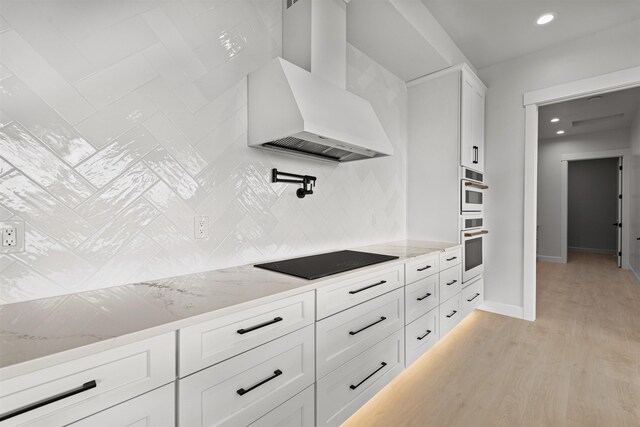 kitchen with white cabinets, a notable chandelier, light wood-type flooring, and a sink