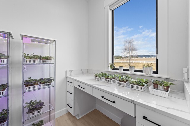 laundry room with stacked washing maching and dryer, recessed lighting, cabinet space, a sink, and marble finish floor