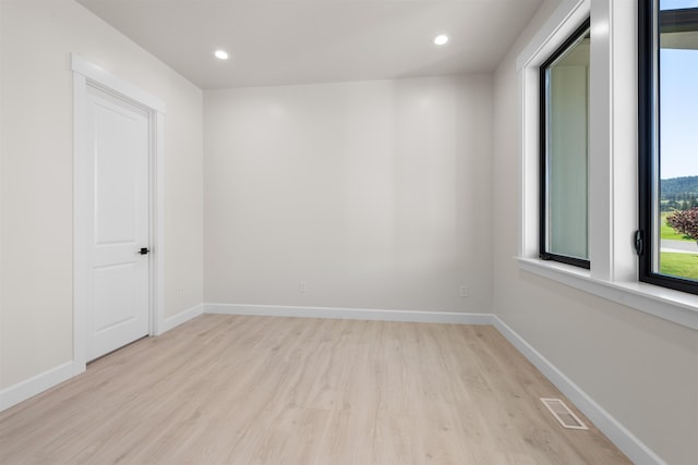 empty room with light wood-type flooring, visible vents, baseboards, and recessed lighting