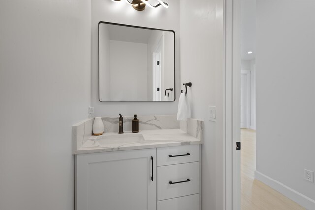 bathroom with vanity, baseboards, and wood finished floors