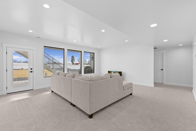 finished basement with stairway, recessed lighting, and light colored carpet