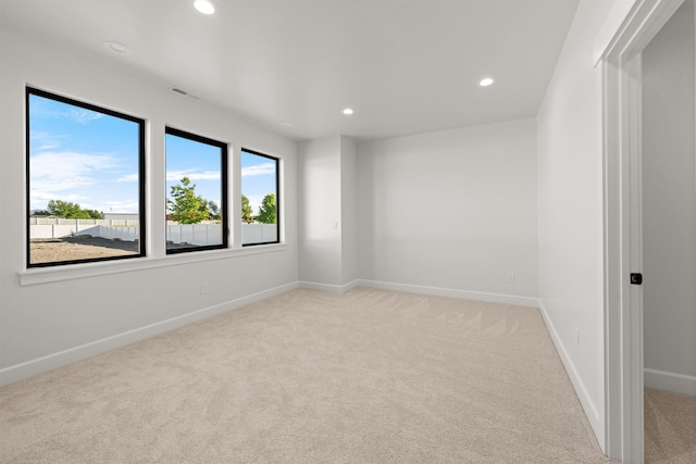 unfurnished room featuring visible vents, recessed lighting, light colored carpet, and baseboards