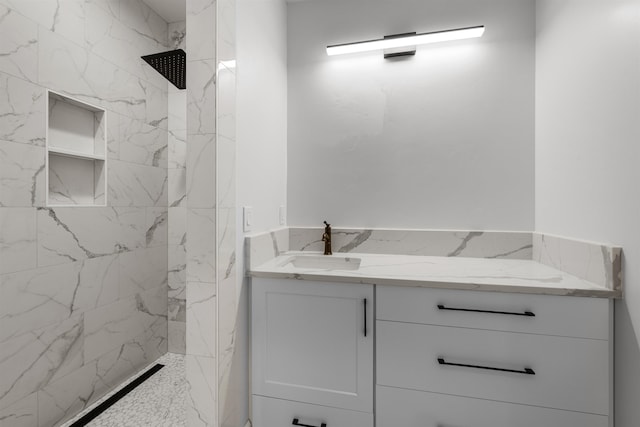 full bathroom featuring a marble finish shower and vanity