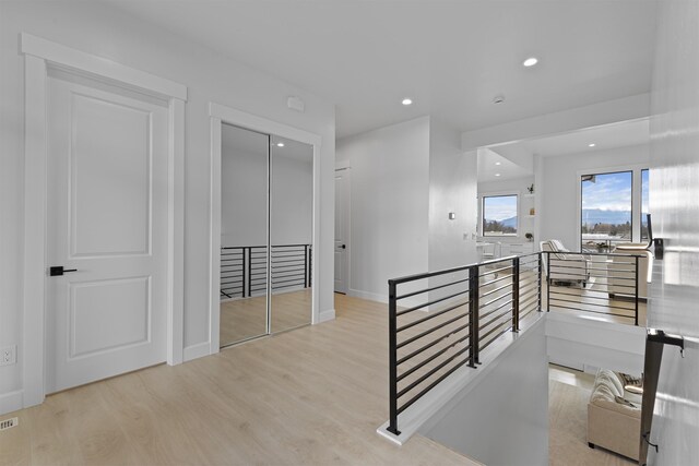 corridor featuring visible vents, an upstairs landing, wood finished floors, recessed lighting, and baseboards