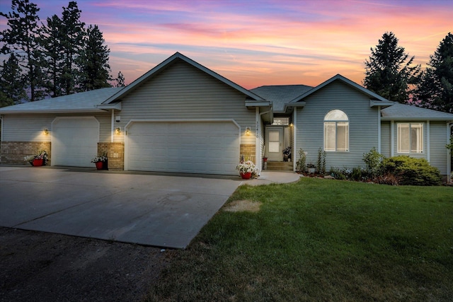 ranch-style home with an attached garage, driveway, and a front lawn