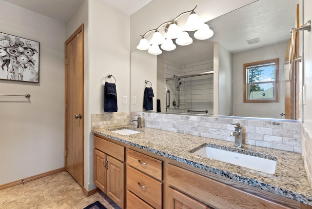 bathroom featuring double vanity, visible vents, a stall shower, and a sink