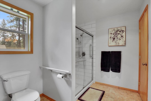 full bath with a stall shower, toilet, and baseboards