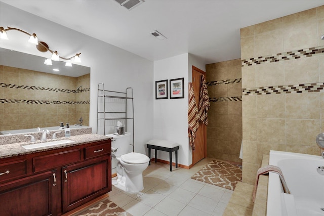 bathroom with tile patterned flooring, visible vents, vanity, and a bathtub