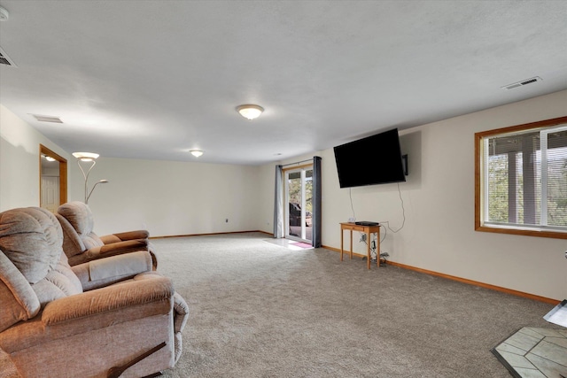 carpeted living area featuring visible vents and baseboards