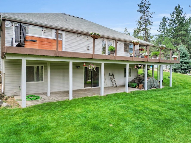 back of house with a patio, a lawn, and a shingled roof