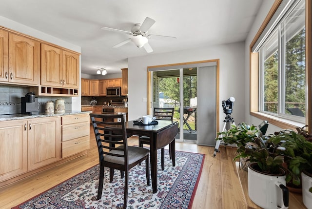 dining space with light wood-type flooring and ceiling fan