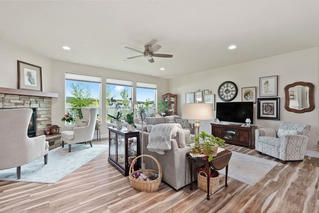 living area with recessed lighting, light wood-style floors, and a fireplace