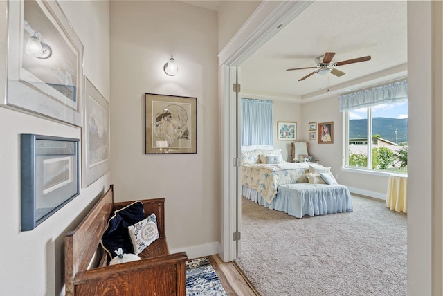 bedroom with light carpet, ceiling fan, and baseboards