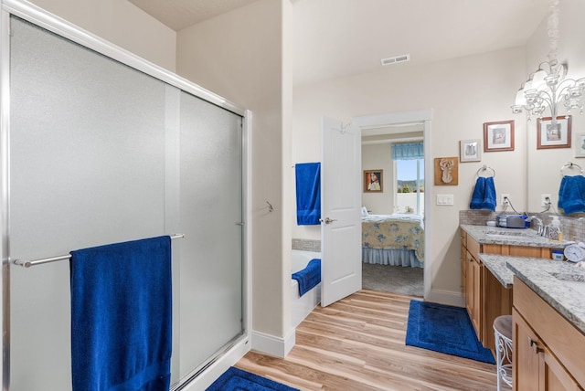 full bath with vanity, wood finished floors, visible vents, a shower stall, and ensuite bathroom