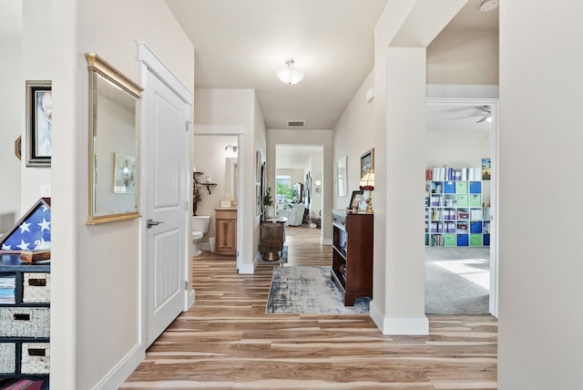 foyer with light wood finished floors, visible vents, and baseboards