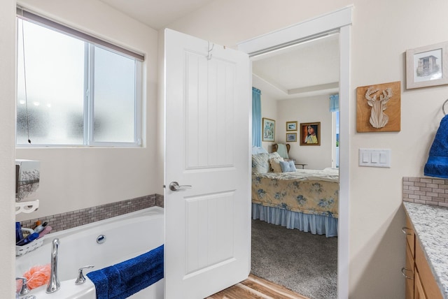 ensuite bathroom with vanity, a bath, and ensuite bathroom