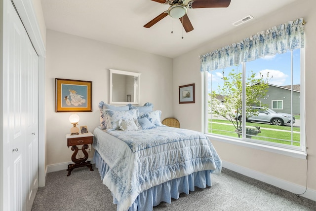 carpeted bedroom featuring a ceiling fan, baseboards, visible vents, and a closet