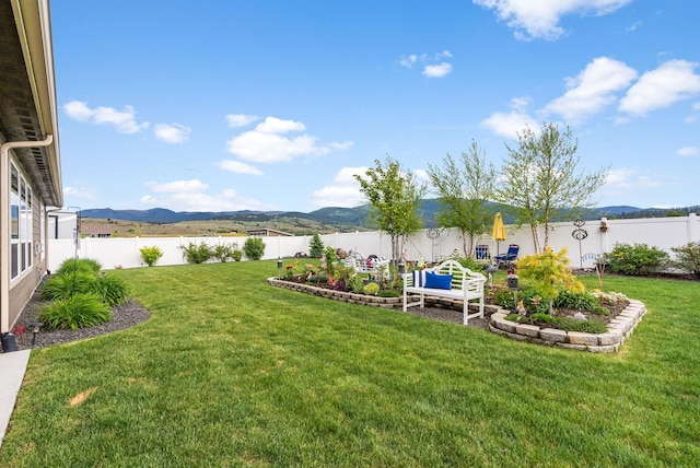 view of yard featuring a mountain view and a fenced backyard