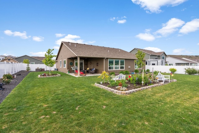 back of property featuring a yard, a vegetable garden, a fenced backyard, and a patio area