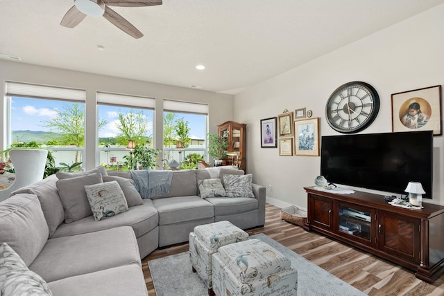 living area with ceiling fan, baseboards, light wood-style flooring, and recessed lighting