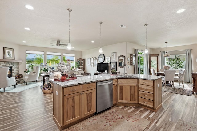 kitchen with visible vents, light wood finished floors, a sink, dishwasher, and open floor plan