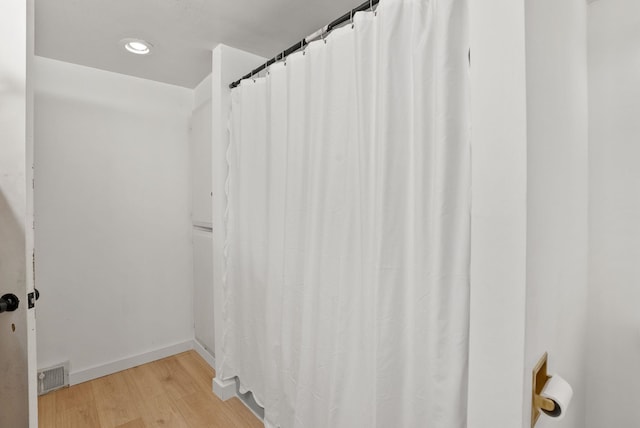 full bathroom featuring visible vents, baseboards, and wood finished floors