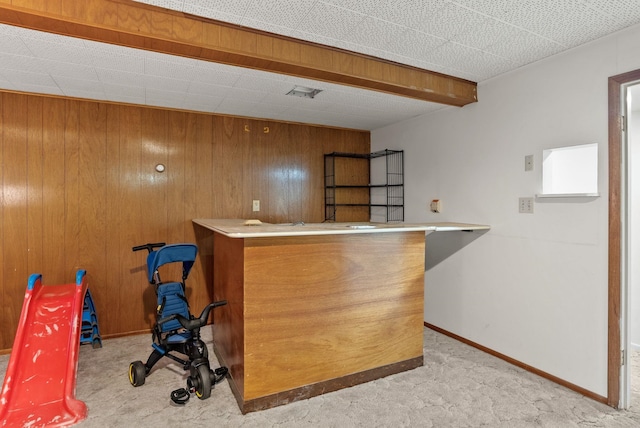 bar featuring visible vents, baseboards, wood walls, a dry bar, and carpet flooring