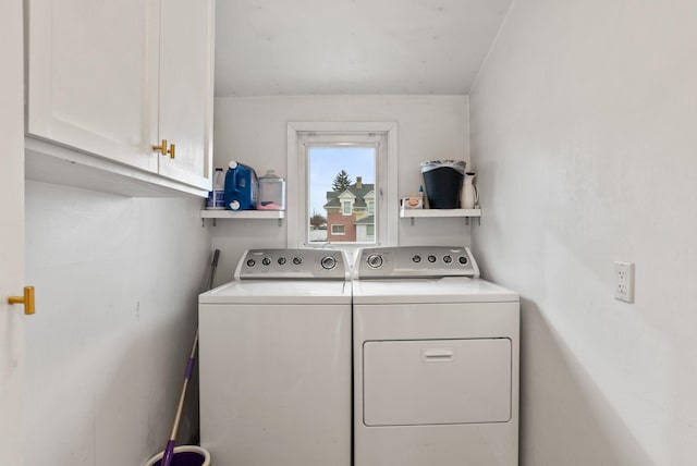 clothes washing area featuring cabinet space and washing machine and dryer