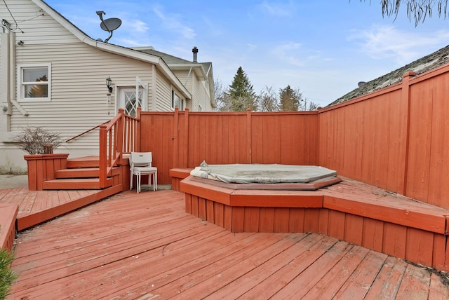 wooden terrace featuring fence and hot tub deck surround