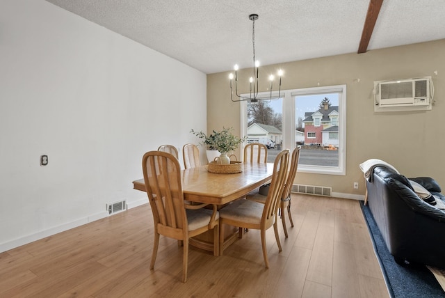 dining room featuring light wood-style floors, visible vents, and a chandelier