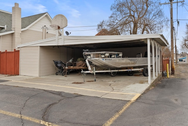 view of parking featuring a carport and fence