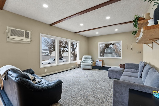 living area featuring a textured ceiling, beamed ceiling, baseboards, and a wall mounted AC