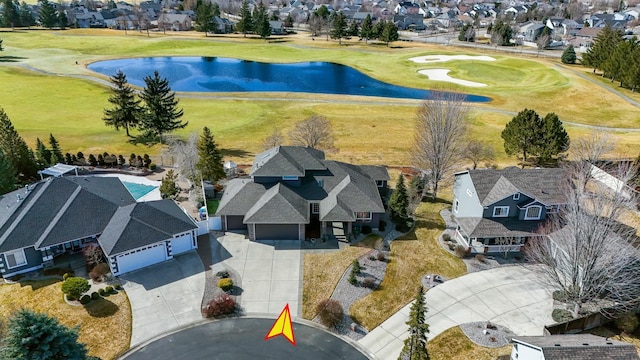 drone / aerial view with a residential view, golf course view, and a water view