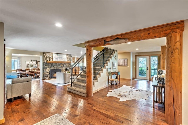 interior space with baseboards, wood-type flooring, a fireplace, and stairs